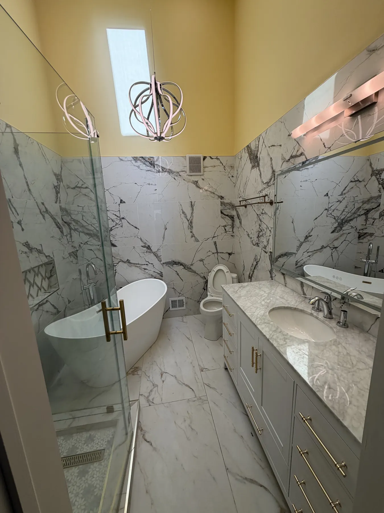 Client-provided photo of a cleaned bathroom with a vanity, tub, toilet, and glass shower