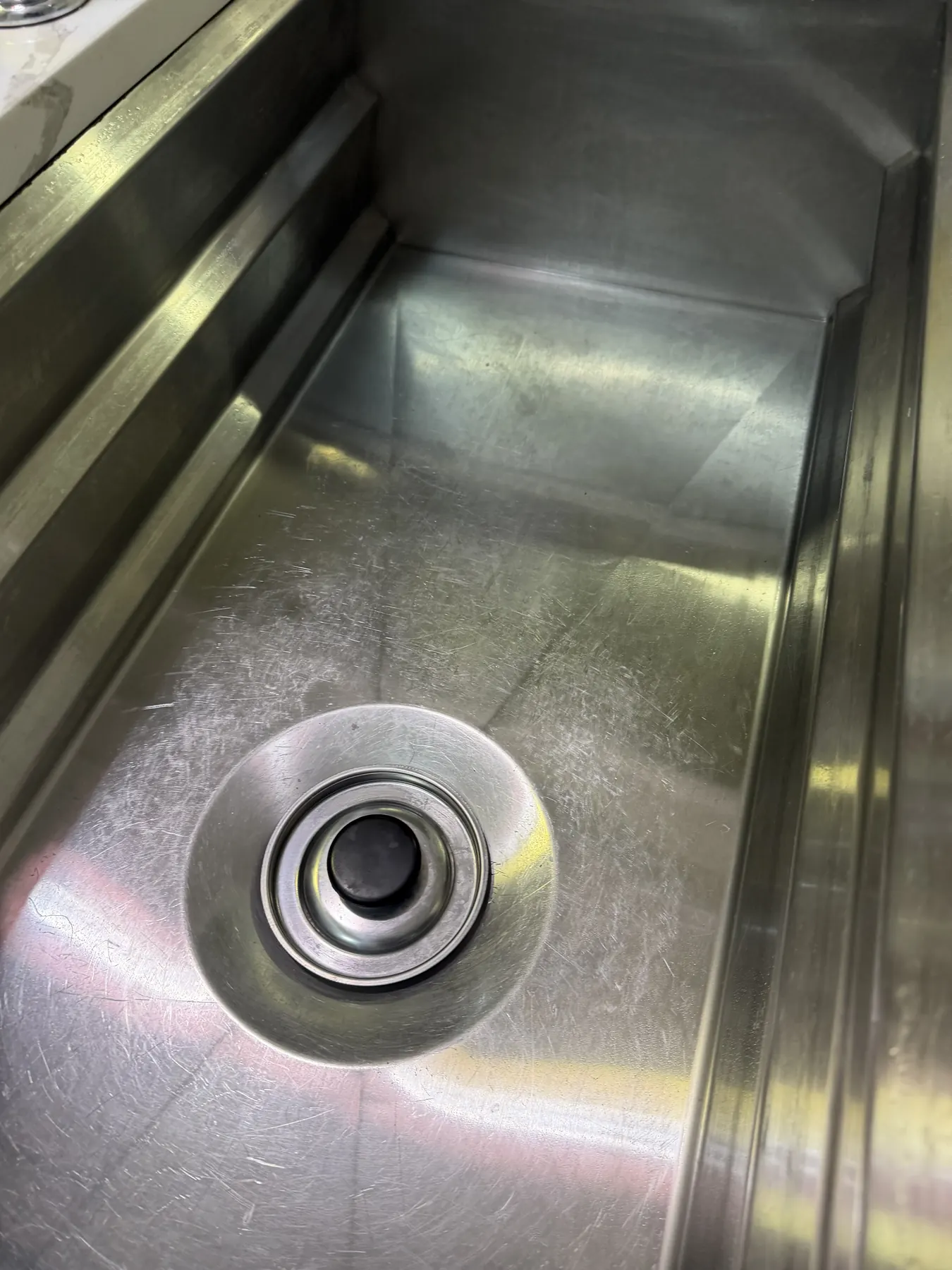 Client-provided after photo showing the stainless-steel sink basin cleaned
