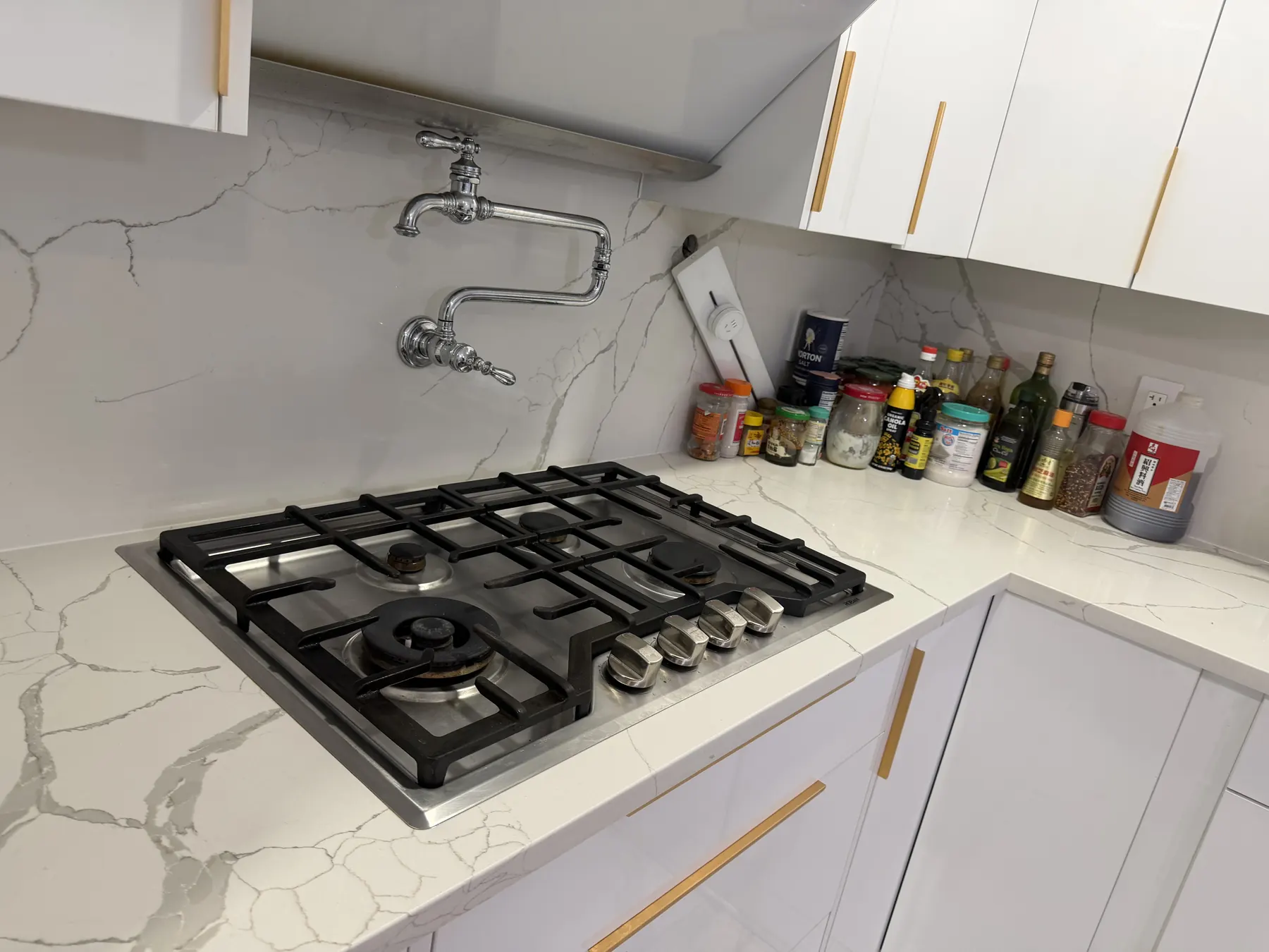 Client-provided after photo showing the cleaned stovetop reassembled in the kitchen