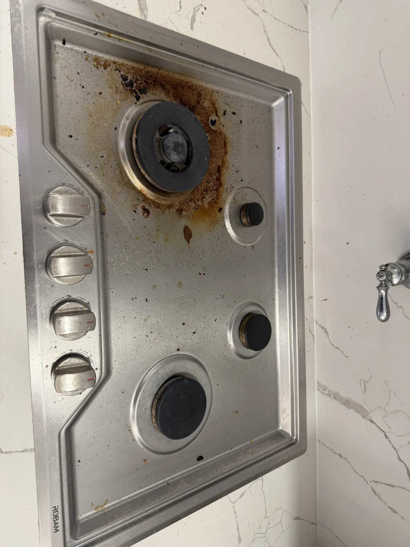 Client-provided before photo showing cooked-on residue across a stovetop