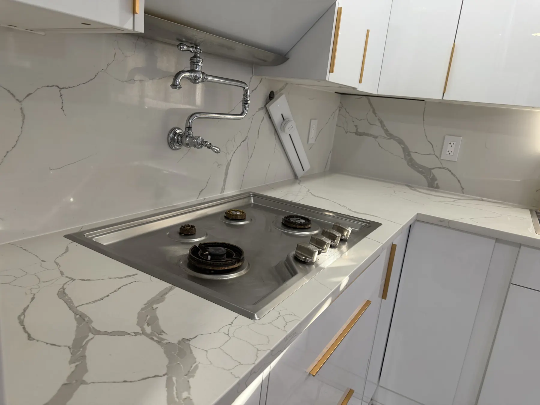 Client-provided in-progress photo showing the stovetop with grates removed for cleaning